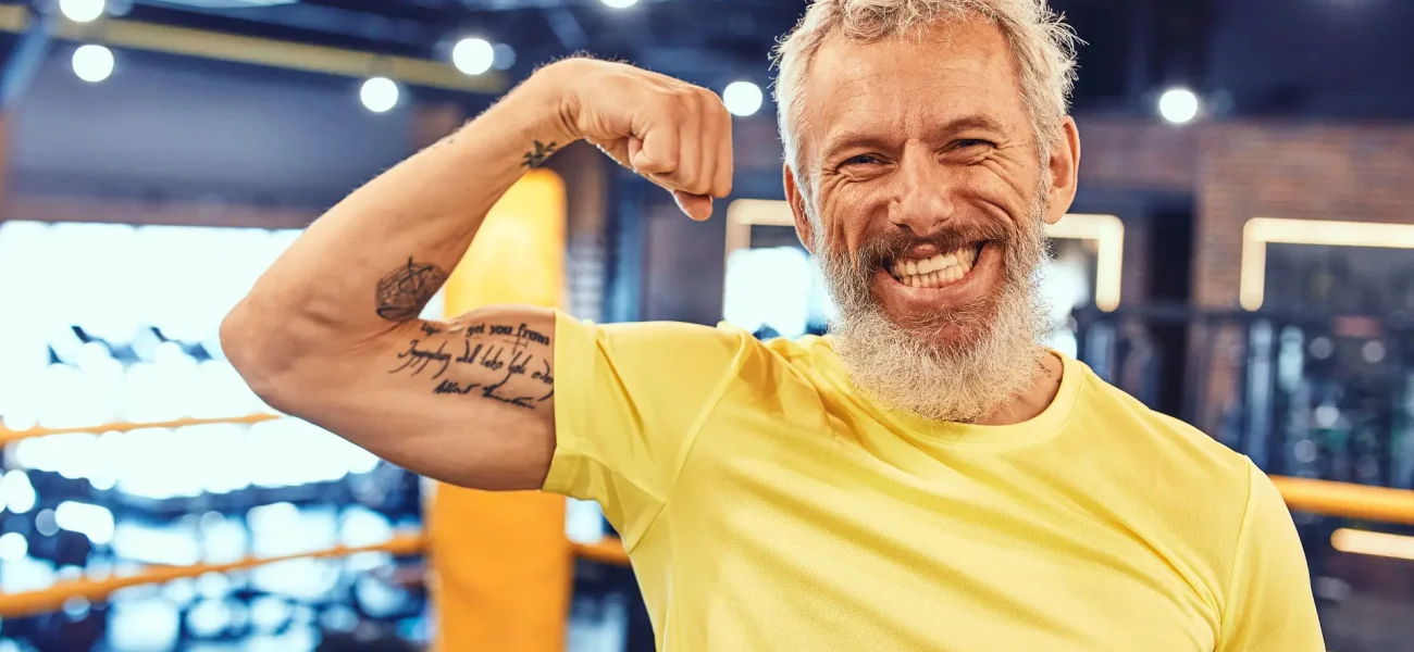 portrait-happy-handsome-mature-man-showing-his-biceps-smiling-camera-while-standing(1)